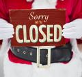 Partial Santa holding Sorry We're Closed sign